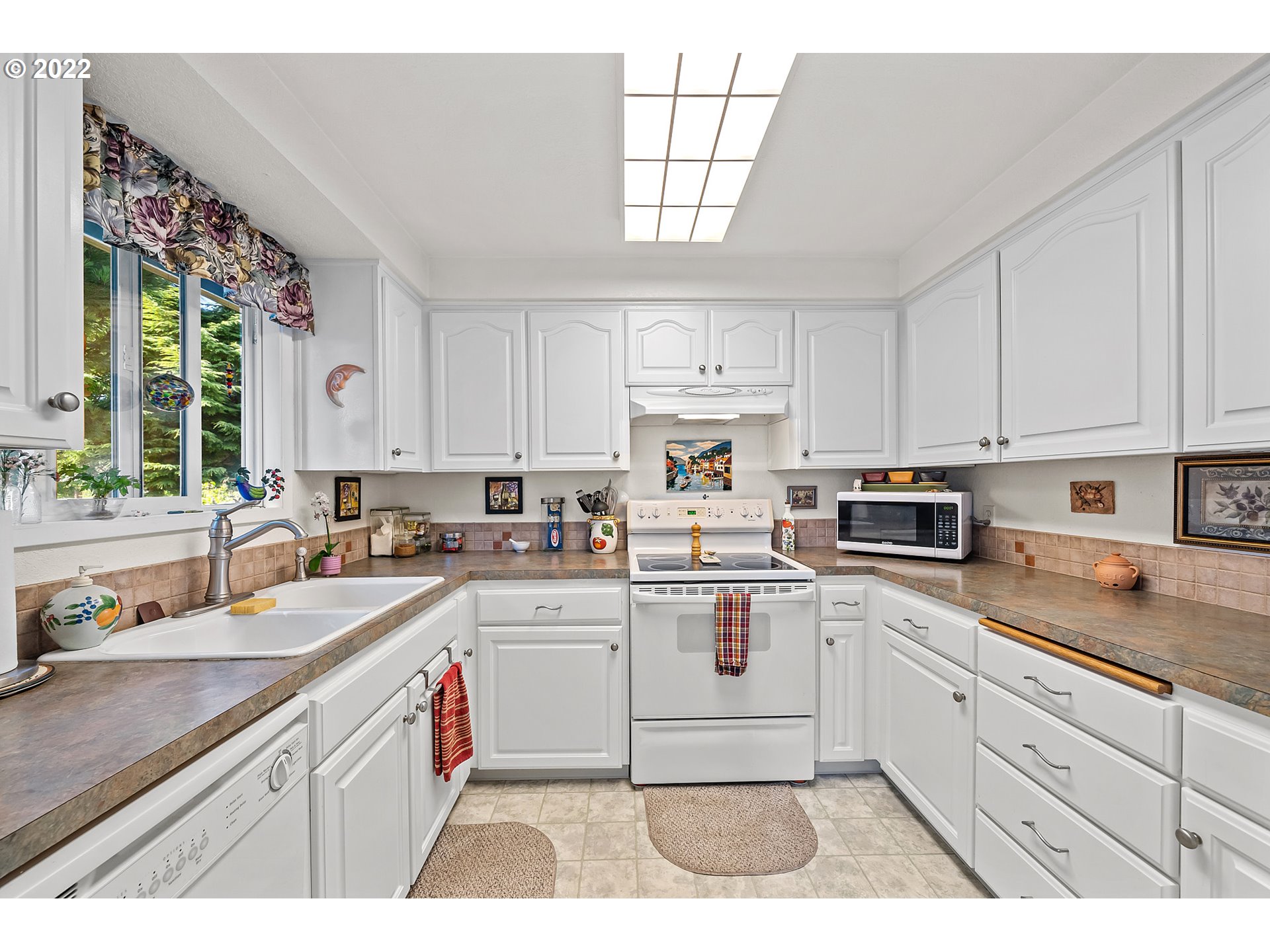 4225 Orchard Loop Netarts, OR 97141 - Photo 9 of 31 a kitchen with a sink window and cabinets