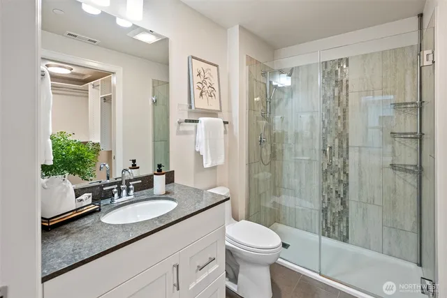 a bathroom with a granite countertop sink toilet and shower