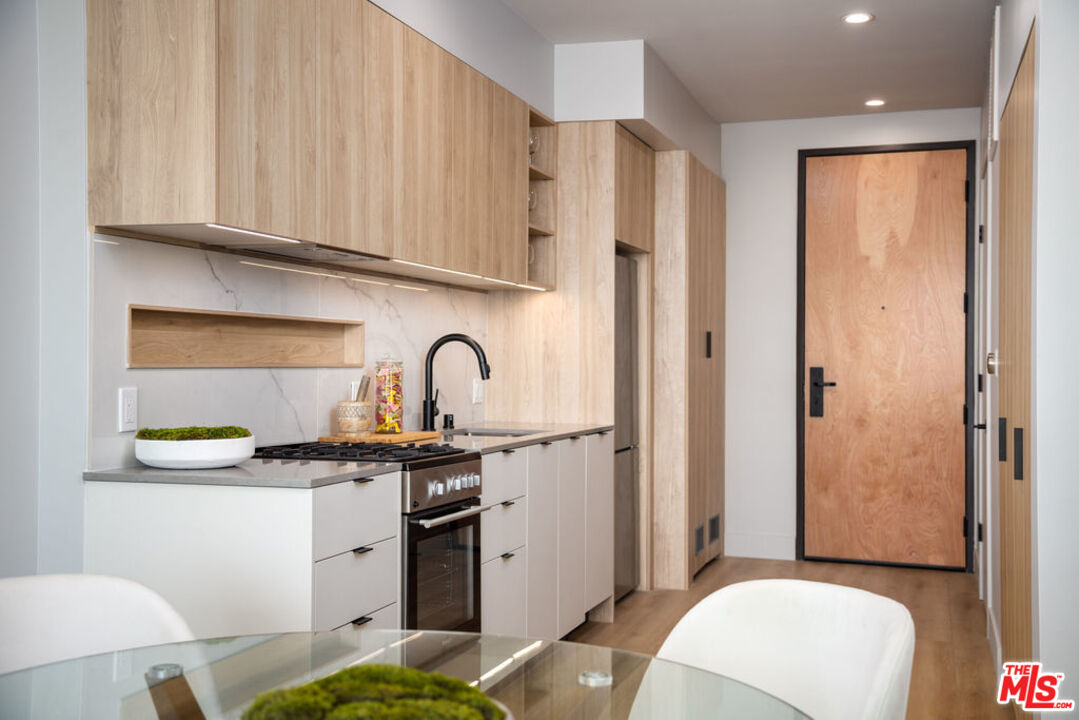 12431 Rochester Avenue, Unit 208 Los Angeles, CA 90025 - Photo 6 of 24 a kitchen with stainless steel appliances granite countertop a sink and a refrigerator