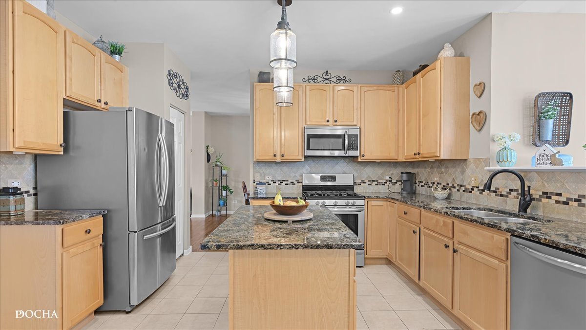 420 Raintree Drive Oswego, IL 60543 - Photo 11 of 51 a kitchen with stainless steel appliances granite countertop a sink stove and refrigerator