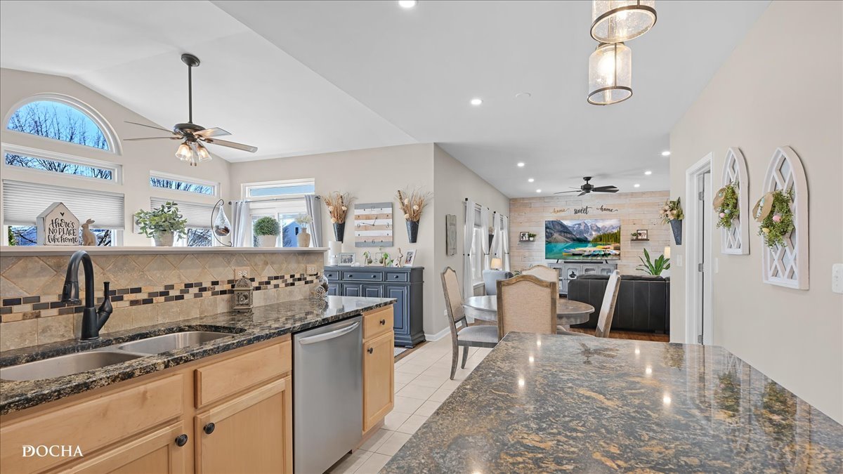 420 Raintree Drive Oswego, IL 60543 - Photo 12 of 51 a kitchen with kitchen island granite countertop a refrigerator and a sink