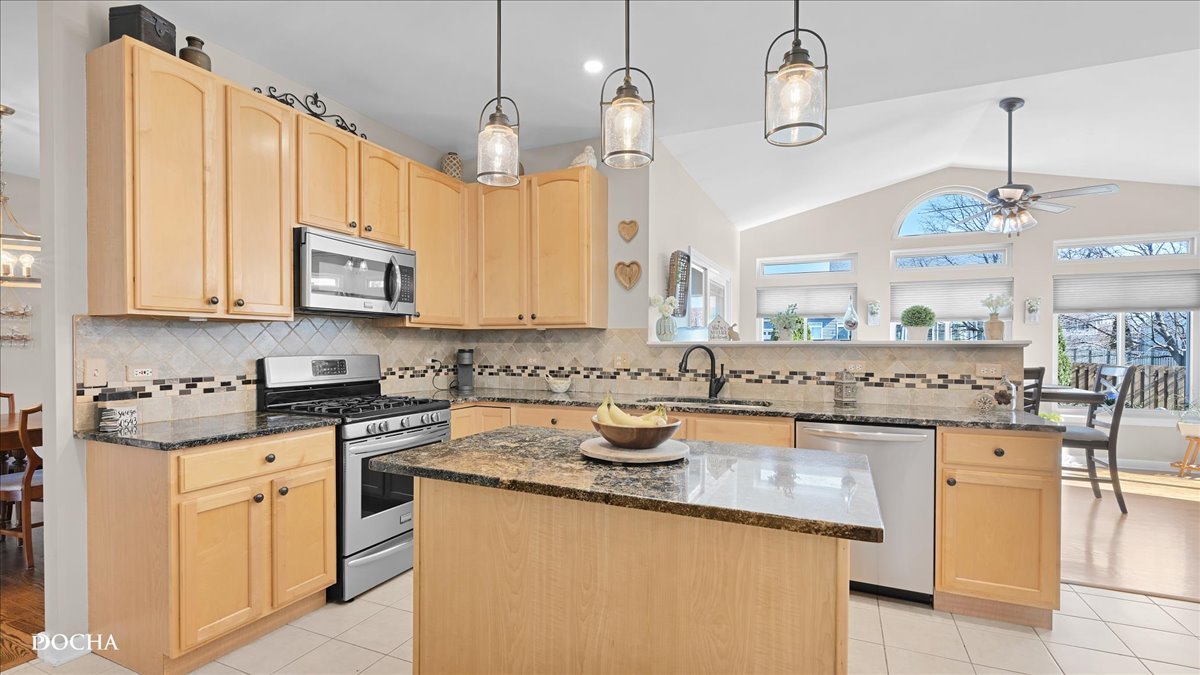 420 Raintree Drive Oswego, IL 60543 - Photo 9 of 51 a kitchen with stainless steel appliances granite countertop a stove a sink and a microwave