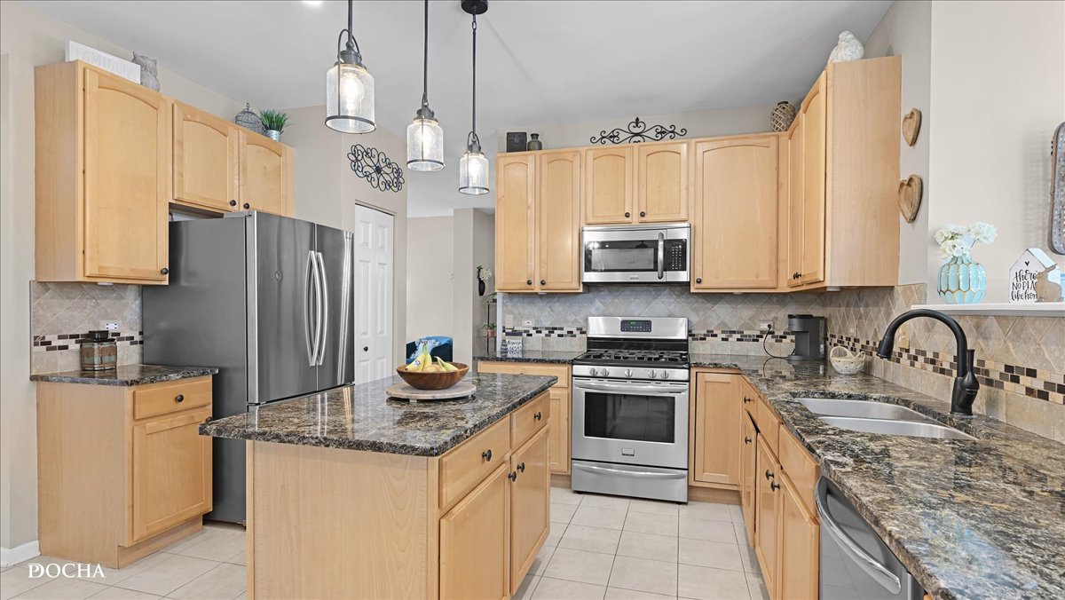 420 Raintree Drive Oswego, IL 60543 - Photo 10 of 51 a kitchen with granite countertop a sink stove and refrigerator