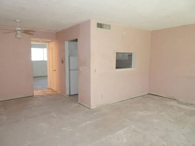 an empty room with windows and closet
