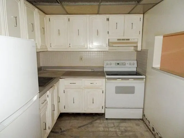 a kitchen with white cabinets and white appliances