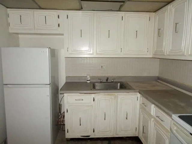 a kitchen with granite countertop white cabinets and white appliances