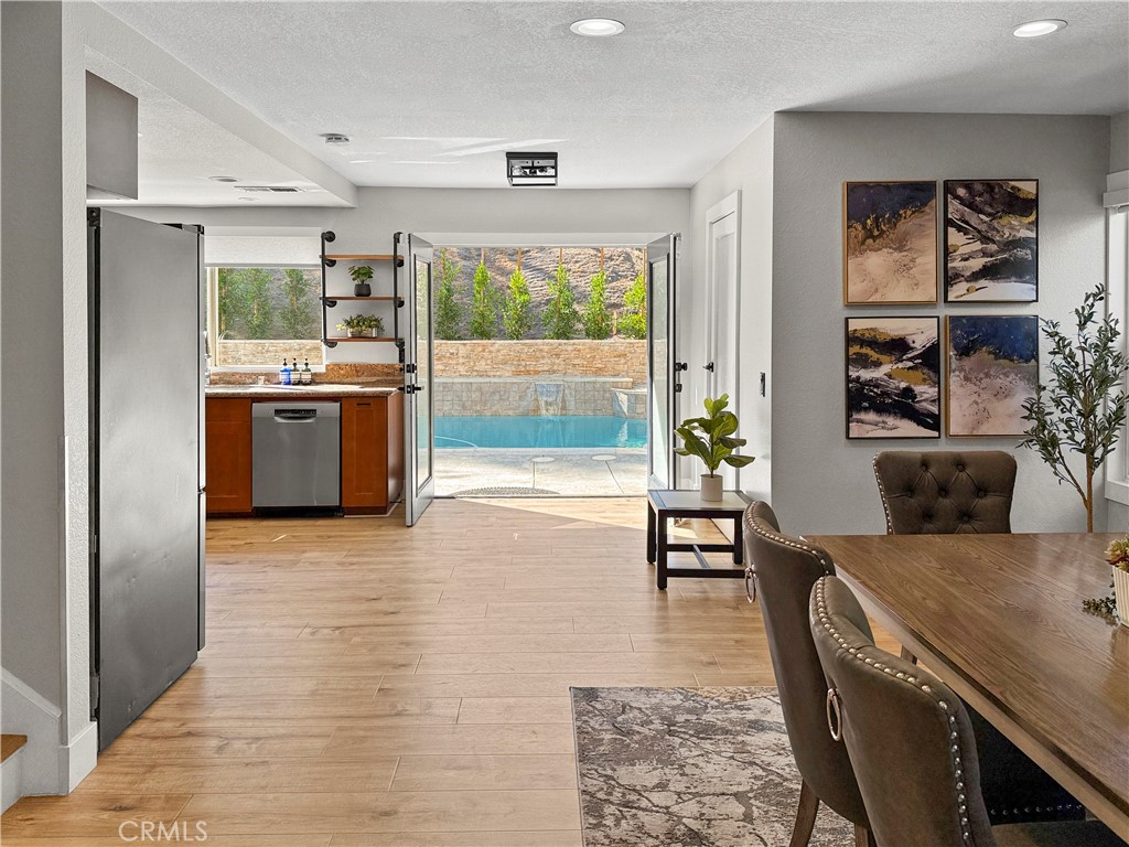 16955 Lake Knoll Parkway Riverside, CA 92503 - Photo 12 of 42 a kitchen with stainless steel appliances granite countertop a stove top oven a sink a dining table and chairs with wooden floor