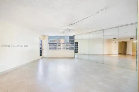a view of a big room with wooden cabinet and windows