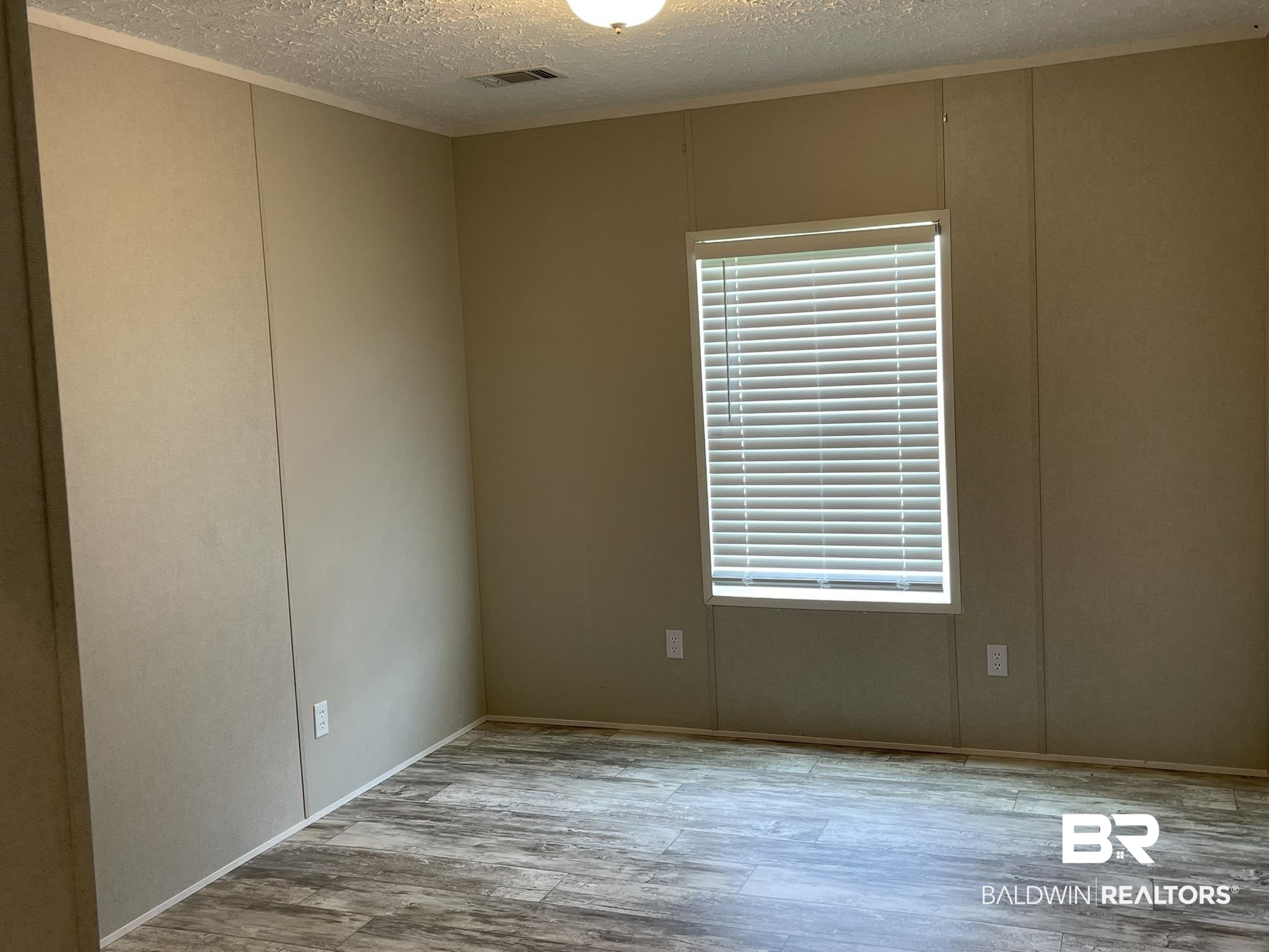 16802 County Road 87 Elberta, AL 36530 - Photo 12 of 19 Spare room with wood finished floors, a textured ceiling, and a decorative wall