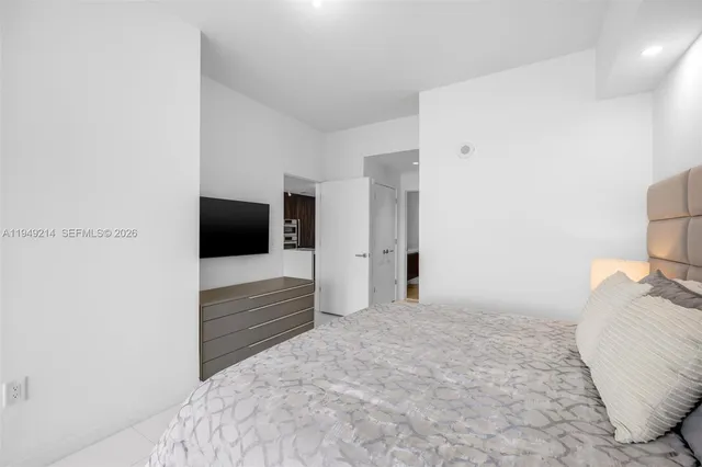 a bedroom with a bed and a flat screen tv