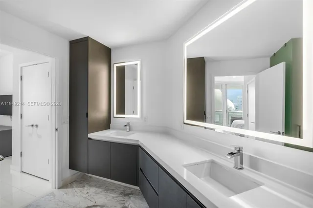 a bathroom with double sink and a mirror