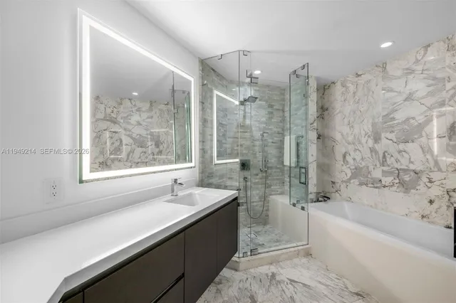 a bathroom with a bathtub a shower a sink and mirror