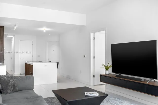 a living room with a flat screen tv and white walls