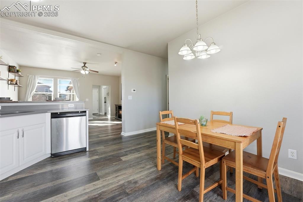 6535 Gelbvieh Road Peyton, CO 80831 - Photo 12 of 41 Dining space with a ceiling fan, dark wood finished floors, and a chandelier