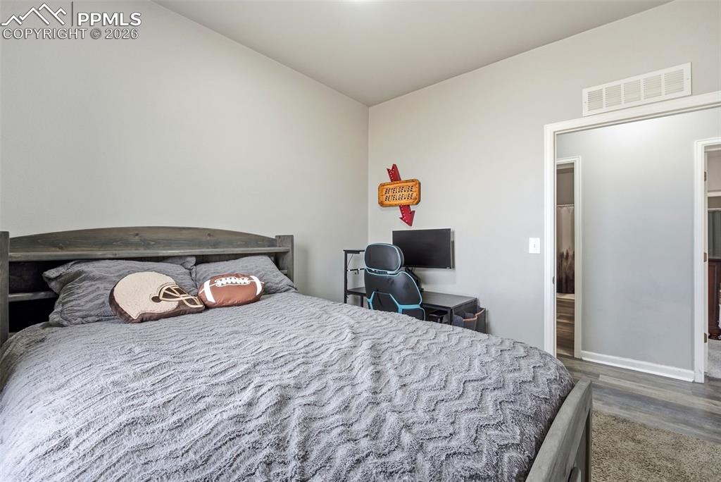 6535 Gelbvieh Road Peyton, CO 80831 - Photo 15 of 41 Bedroom featuring dark wood-type flooring and baseboards