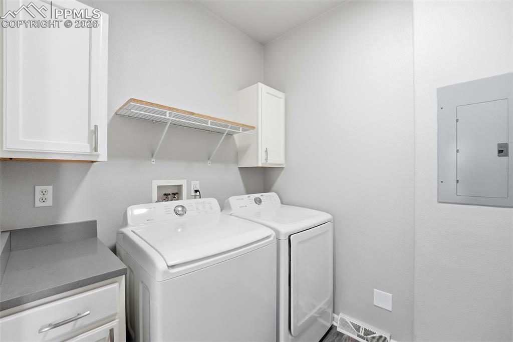 6535 Gelbvieh Road Peyton, CO 80831 - Photo 25 of 41 Laundry area with cabinet space, electric panel, and washing machine and dryer