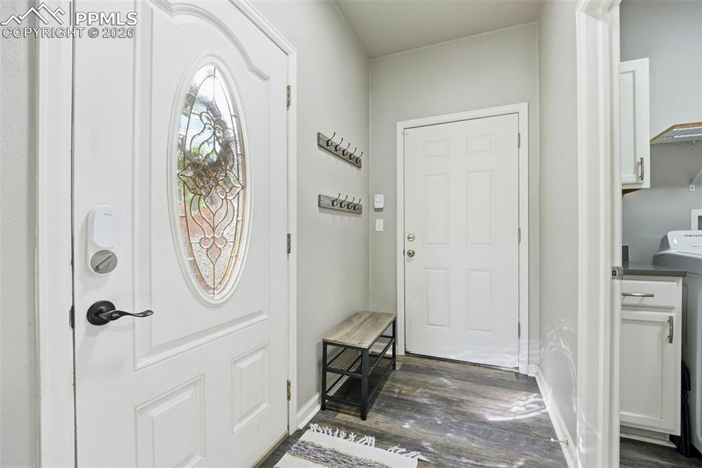 6535 Gelbvieh Road Peyton, CO 80831 - Photo 26 of 41 Entryway with washer / dryer and dark wood-type flooring