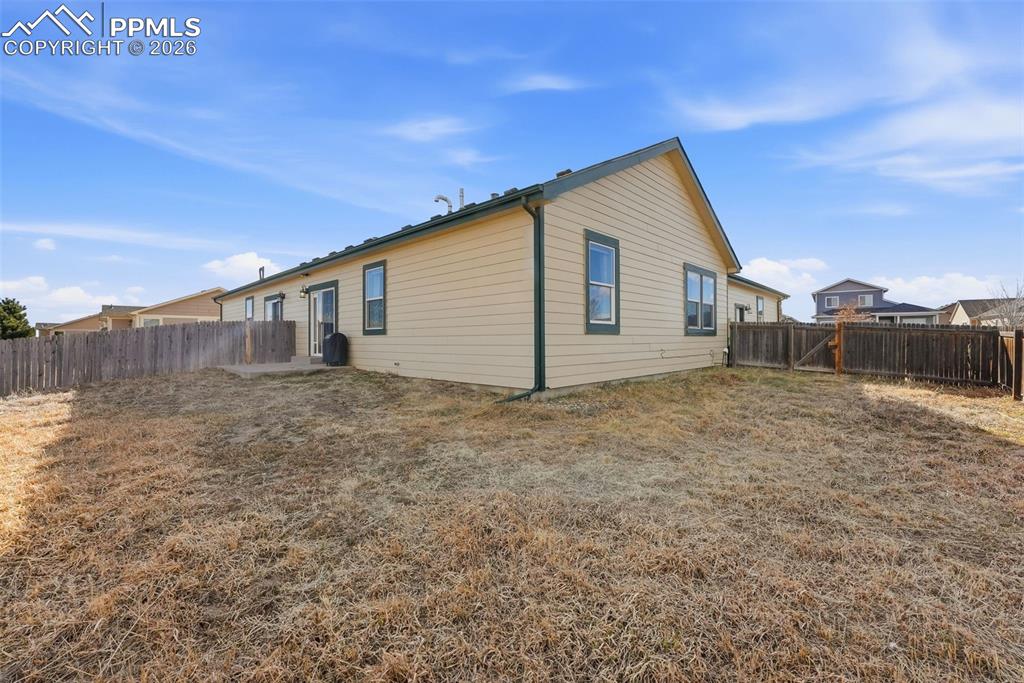 6535 Gelbvieh Road Peyton, CO 80831 - Photo 29 of 41 Rear view of house featuring a fenced backyard and a patio