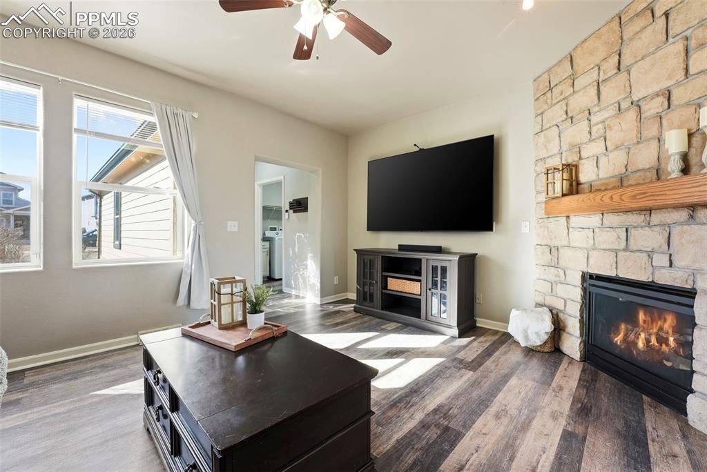 6535 Gelbvieh Road Peyton, CO 80831 - Photo 6 of 41 Living room featuring a fireplace, ceiling fan, dark wood-type flooring, and washer / dryer