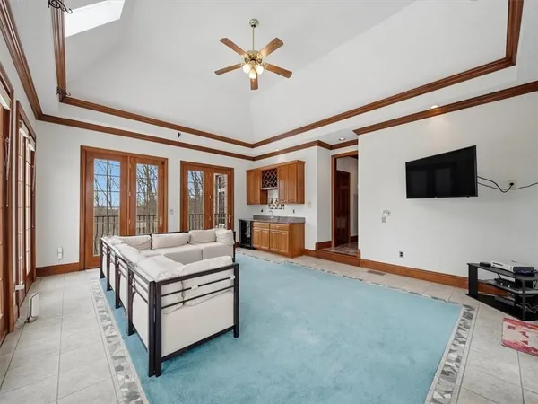 a living room with stainless steel appliances kitchen island granite countertop furniture and a flat screen tv