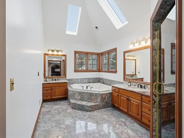 a spacious bathroom with a tub a sink a mirror and a bathtub