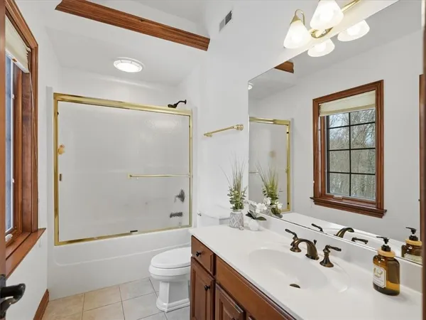 a bathroom with a sink a toilet and a large mirror
