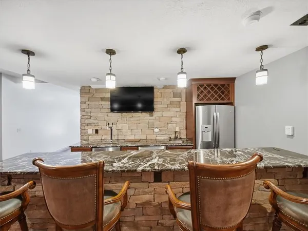 a living room with granite countertop furniture a fireplace and a flat screen tv