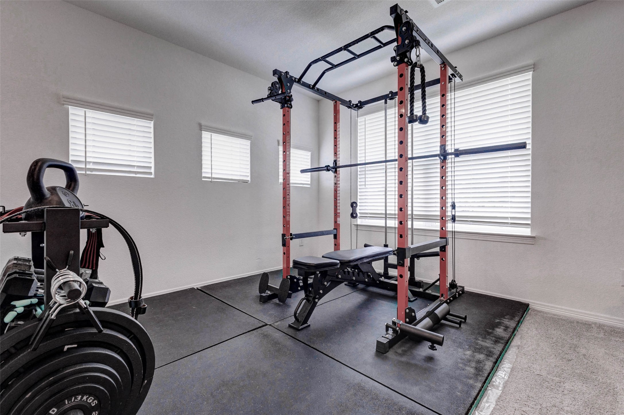 32418 Fly Fish Way Fulshear, TX 77441 - Photo 27 of 40 This bonus area off the game room is currently being used as a home gym, but the possibilities are truly endless. With multiple windows providing ample natural light, the space could easily be transformed into a study, a dedicated gaming setup, or whatever best suits your lifestyle. The sheer size of this combined game room space is one of the most impressive features this home has to offer.