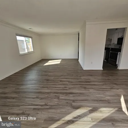 a view of empty room with wooden floor