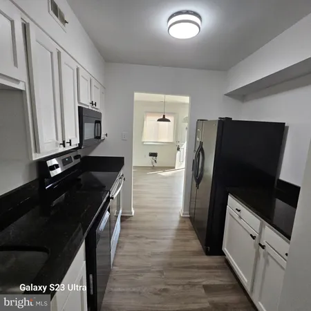 a kitchen with granite countertop a refrigerator stove and sink