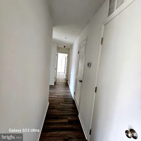 a view of a hallway with wooden floor