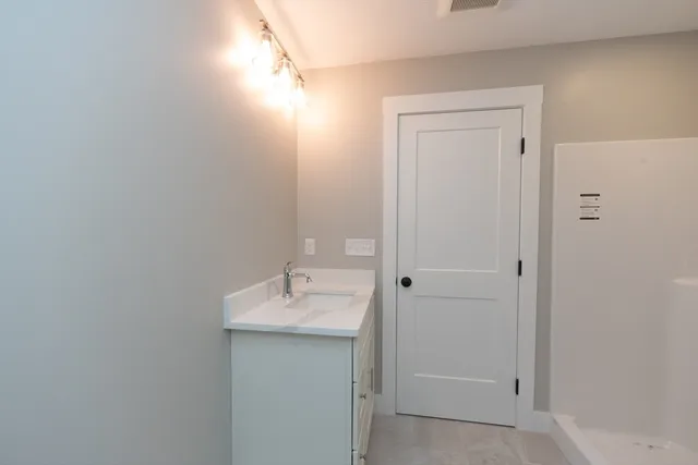 an empty room with windows and chandelier fan