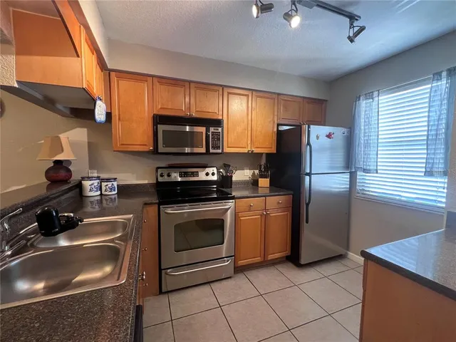 a kitchen with stainless steel appliances granite countertop a sink stove and microwave