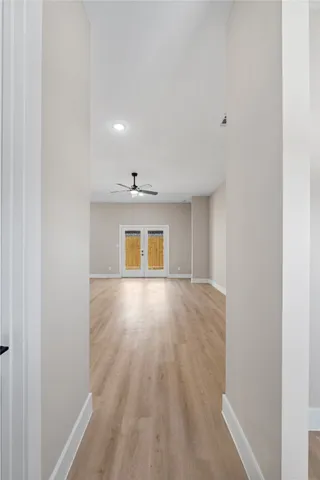 a view of an empty room with wooden floor and a window