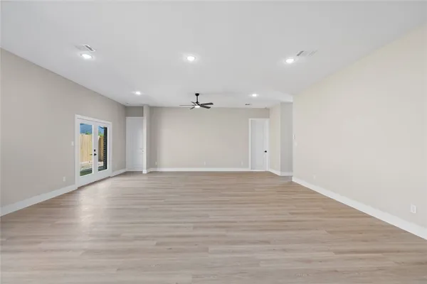 a view of an empty room with wooden floor