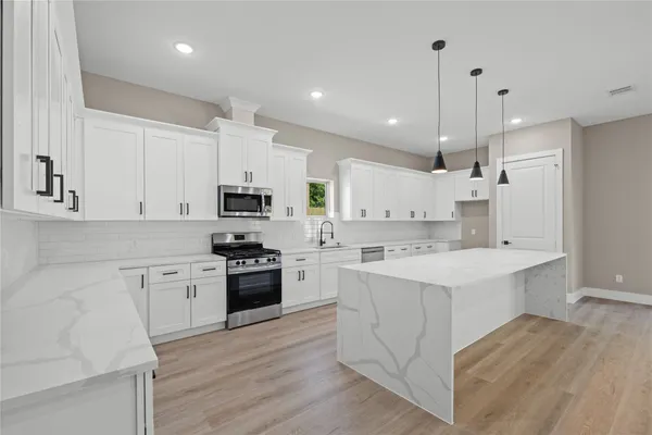 a kitchen with white cabinets and white appliances