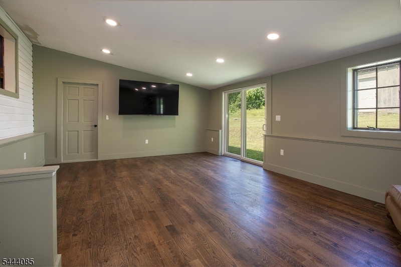 79 Lake Wallkill Road Vernon, NJ 07461 - Photo 8 of 27 an empty room with wooden floor and windows