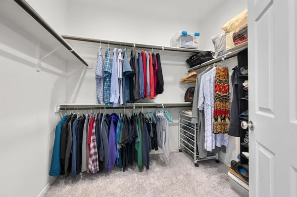 a view of walk in closet with clothes