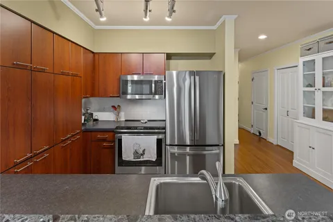 a kitchen with stainless steel appliances granite countertop a refrigerator a sink and a stove