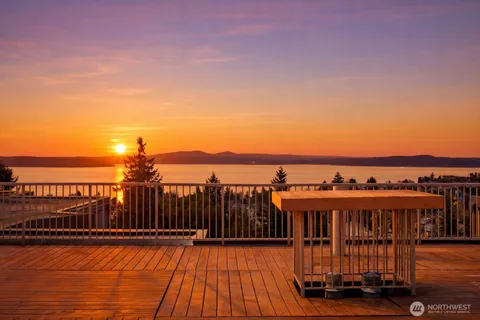 a view of a balcony with wooden floor & fence