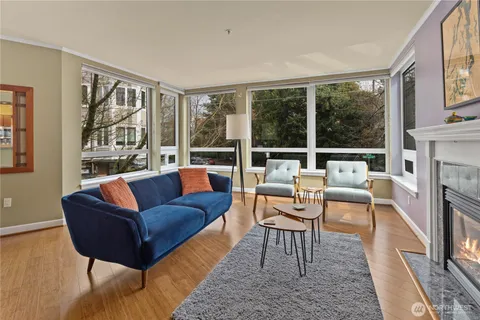 a living room with fireplace furniture and a large window
