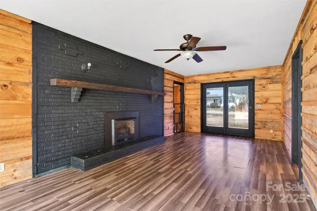 a view of a livingroom with wooden floor and a ceiling fan