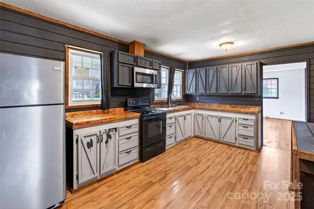 a kitchen with stainless steel appliances granite countertop a stove a sink and a refrigerator