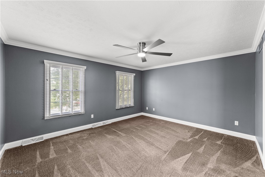 4500 Brooks Road Cleveland, OH 44105 - Photo 20 of 50 Primary bedroom with ornamental molding, carpet, a textured ceiling, and a ceiling fan