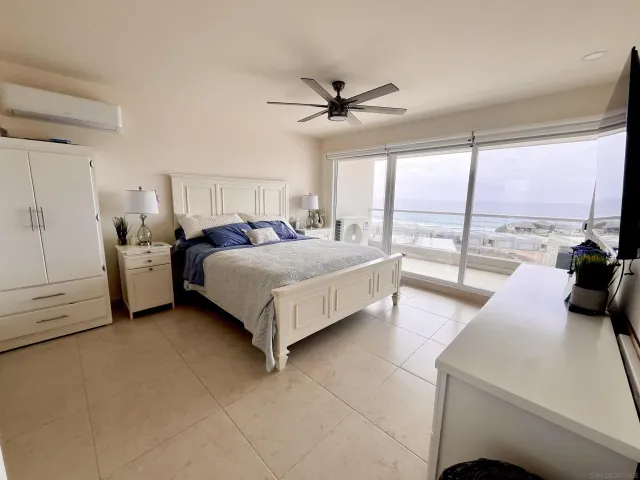 a bedroom with a bed couch and large window