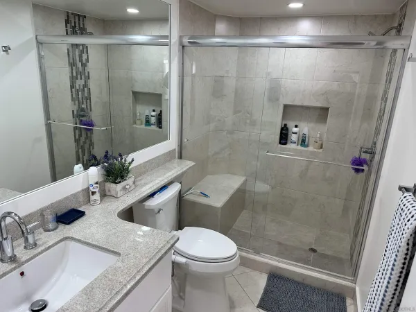 a bathroom with a granite countertop sink toilet and shower