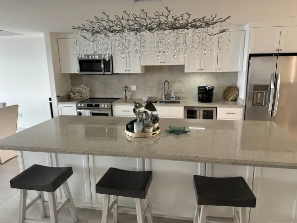 a kitchen with stainless steel appliances granite countertop a sink a stove and a refrigerator