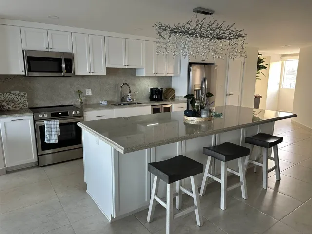 a kitchen with a dining table chairs and a refrigerator