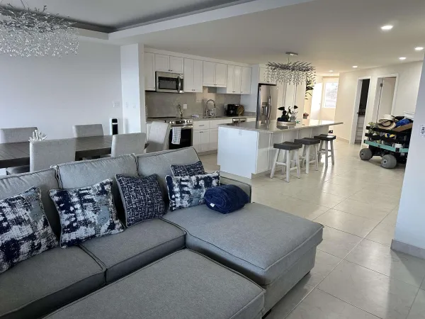 a living room with furniture and a view of kitchen