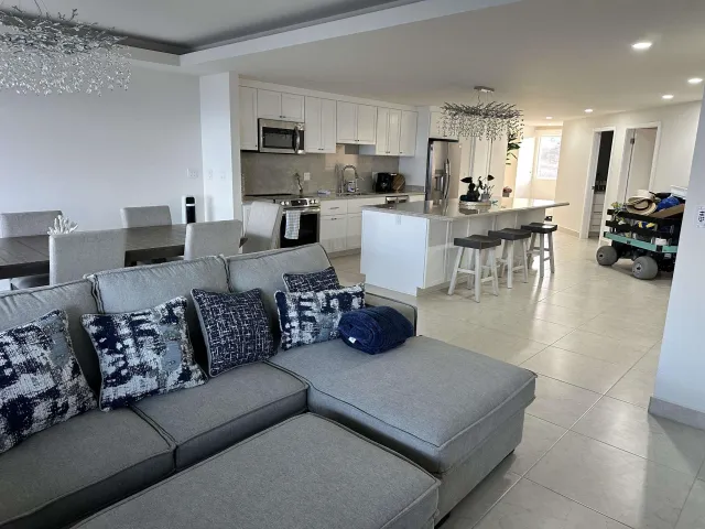 a living room with furniture and a view of kitchen